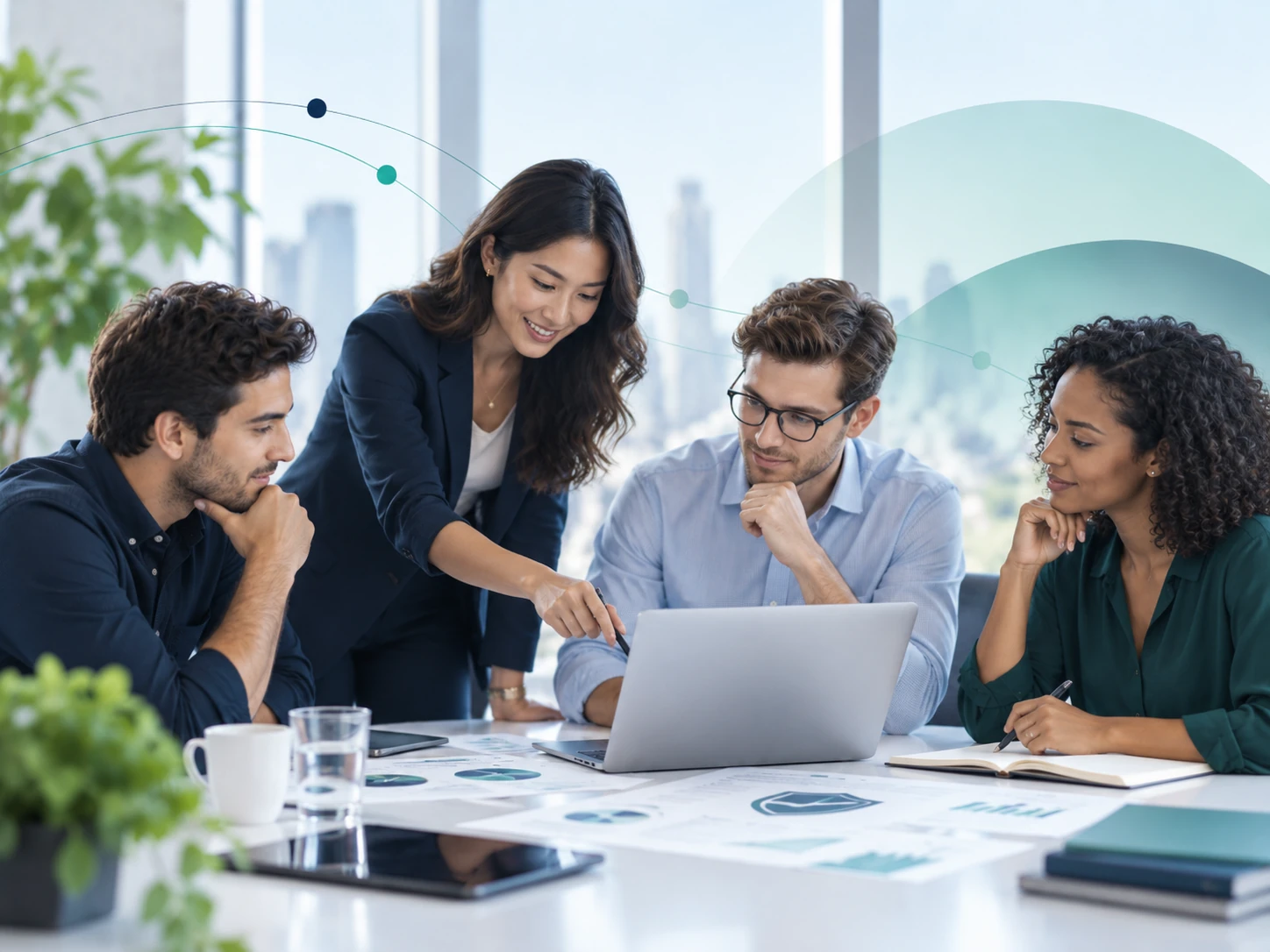 Four colleagues collaborating around a laptop in a bright office