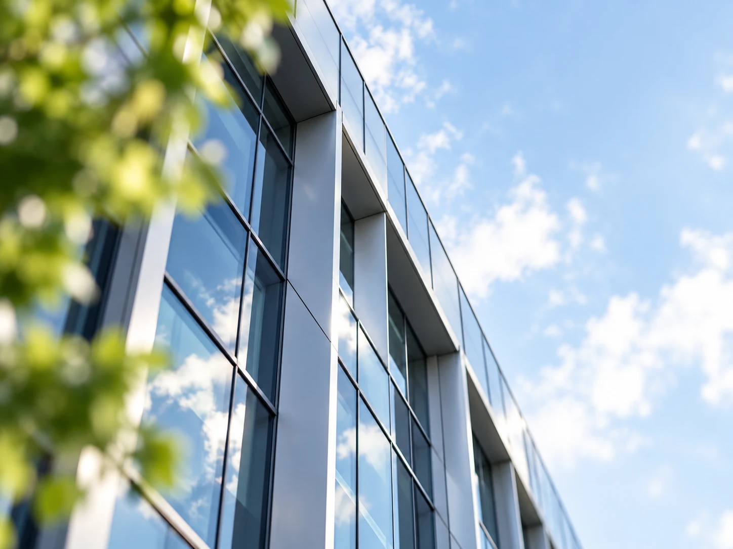 Illustrative glass office building reflecting the sky
